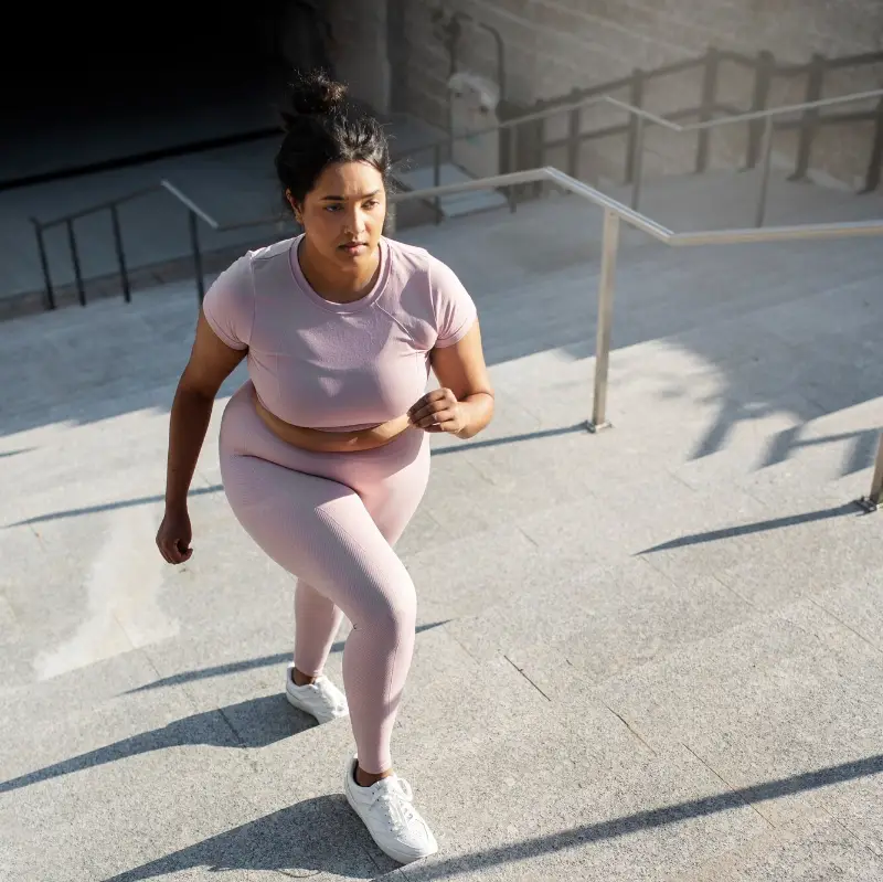 Overweight woman exercising on stairs outdoors